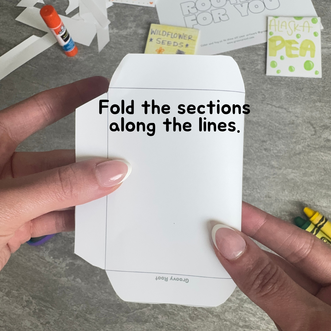Hand holding a white paper with folding instructions on a gray surface.