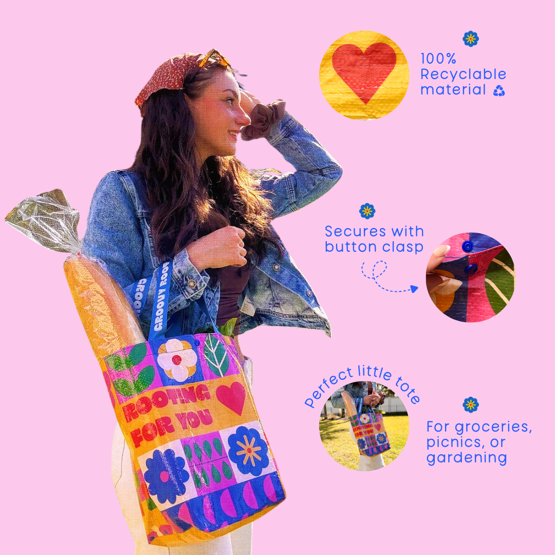 Woman holding a colorful tote bag with text and graphics on a pink background