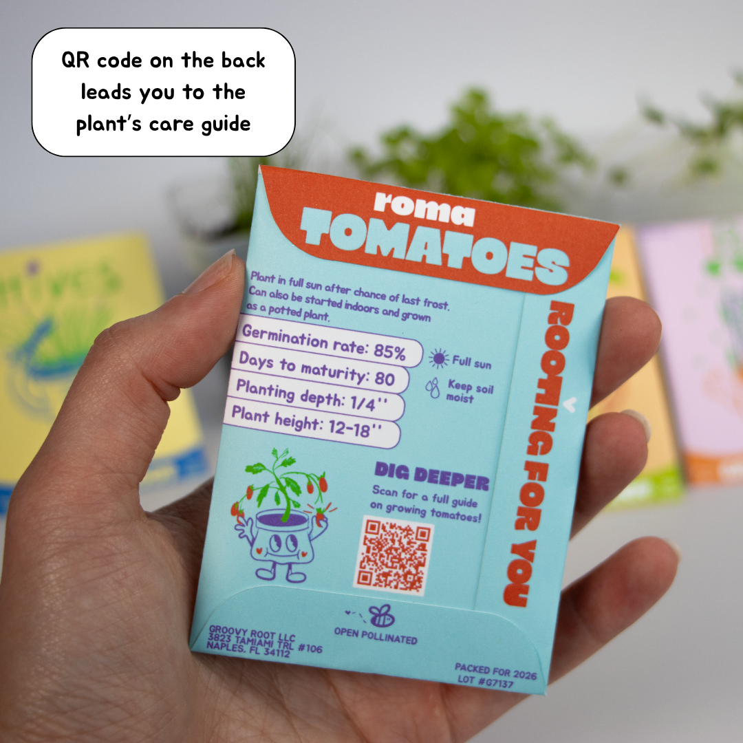 Hand holding a Roma Tomatoes seed packet with a QR code on a blurred background