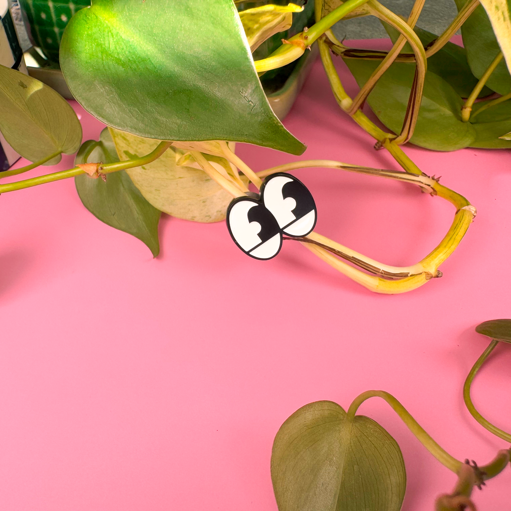 Green leaves on a pink background with a checkered object partially visible