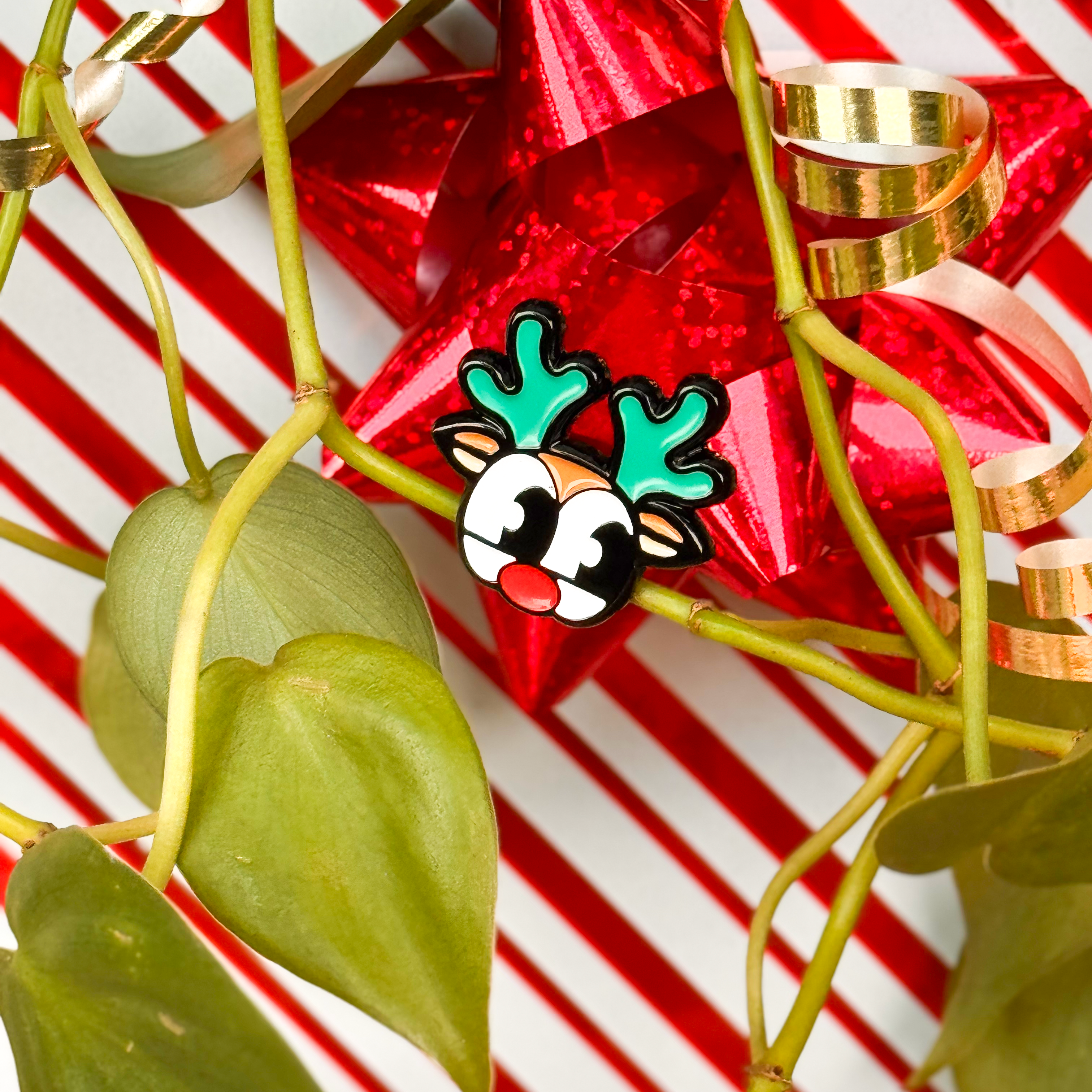 A plant magnet in the shape of rudolph placed on a plant stem