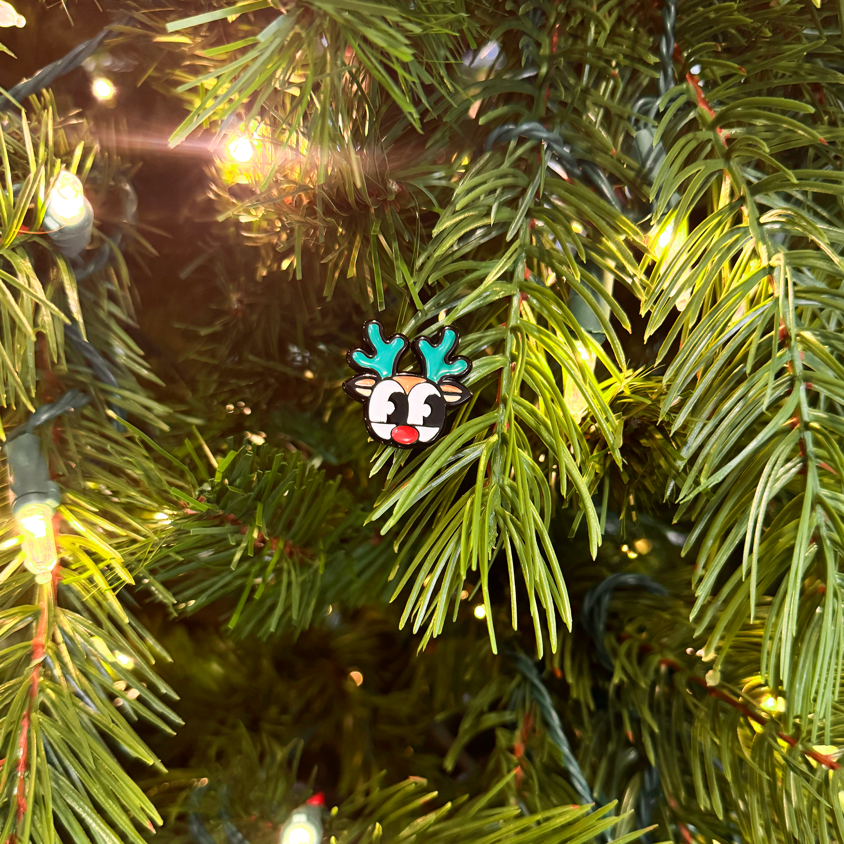 A mini magnet in the shape of rudolph on a christmas tree sprig